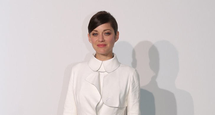 Marion Cotillard bryter av den fina vita trenchcoaten och den strama frisyren med ett par lekfulla, neonfärgade tår.